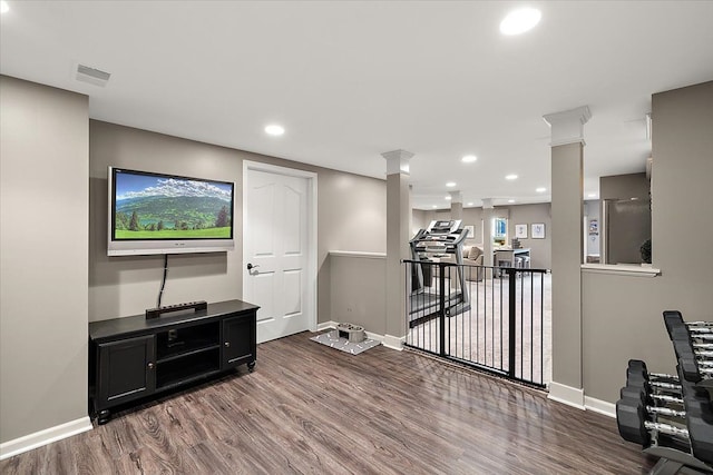 exercise area featuring recessed lighting, baseboards, wood finished floors, and ornate columns