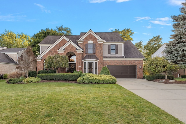 traditional-style house featuring driveway, roof with shingles, an attached garage, a front yard, and brick siding