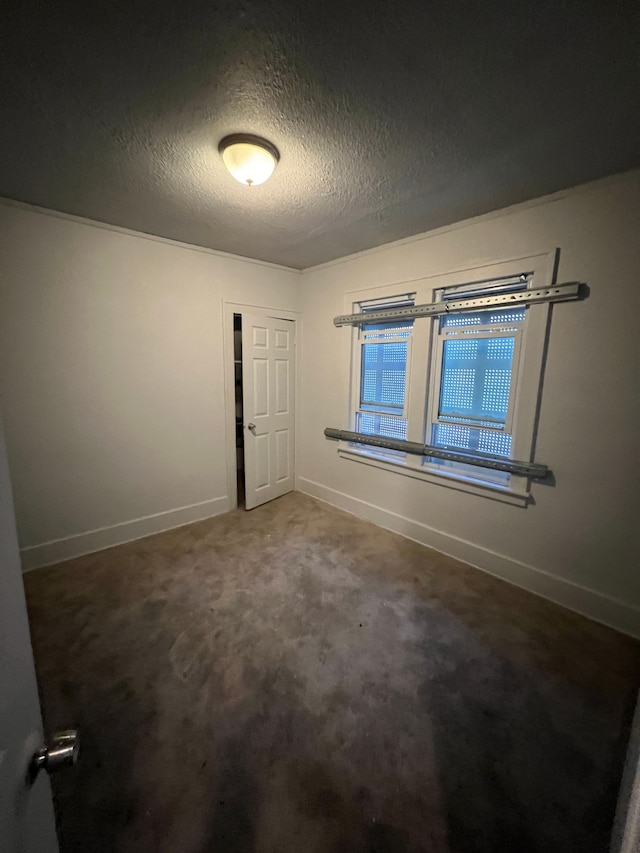 carpeted empty room featuring a textured ceiling