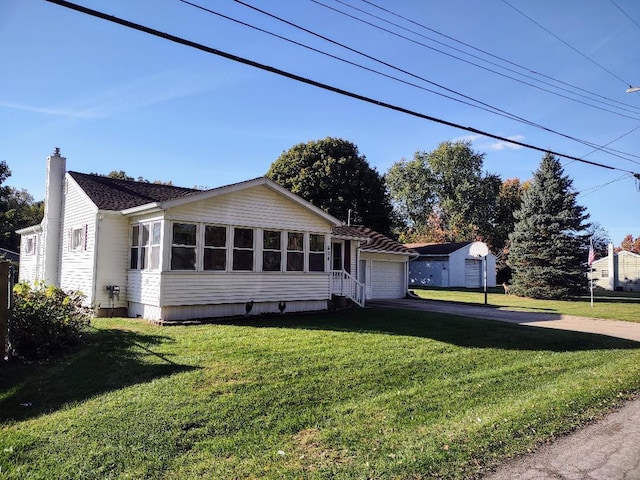 view of front of home with a sunroom, a front lawn, and a garage