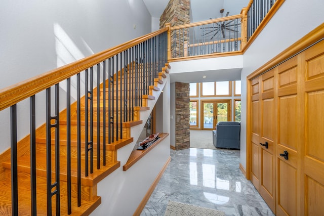 stairs featuring french doors and a towering ceiling