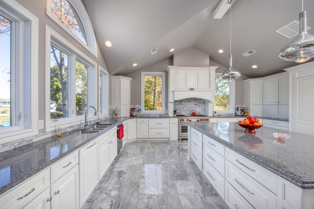 kitchen featuring sink, a center island, stainless steel appliances, pendant lighting, and lofted ceiling