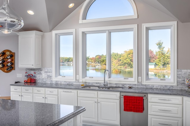 kitchen with backsplash, sink, a water view, white cabinets, and lofted ceiling