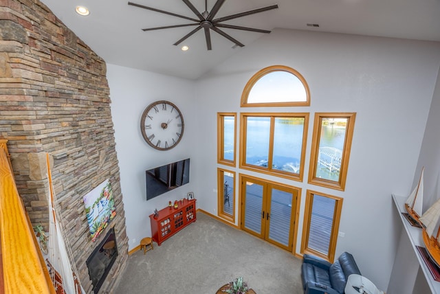 unfurnished living room featuring a fireplace, carpet floors, and high vaulted ceiling