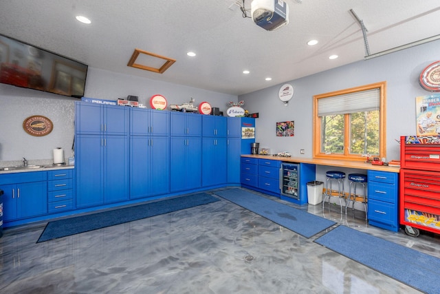 miscellaneous room with wine cooler, sink, a textured ceiling, and dark colored carpet