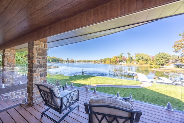 wooden deck featuring a boat dock, a water view, and a yard