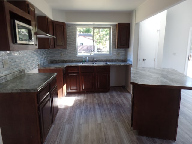 kitchen featuring a center island, hardwood / wood-style flooring, tasteful backsplash, and sink