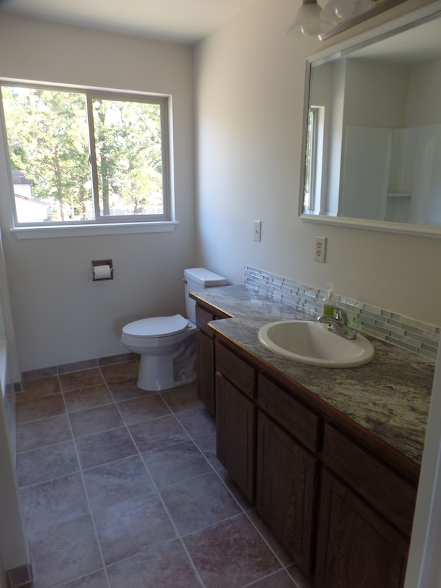 bathroom with backsplash, tile patterned floors, vanity, and toilet