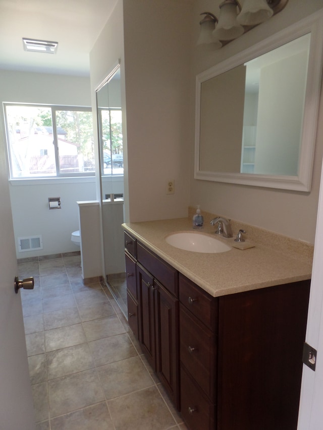 bathroom with tile patterned flooring, vanity, toilet, and an enclosed shower