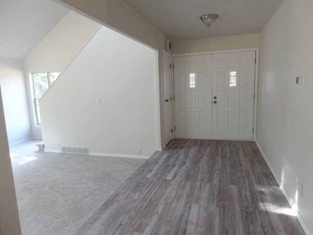 foyer featuring vaulted ceiling and dark wood-type flooring