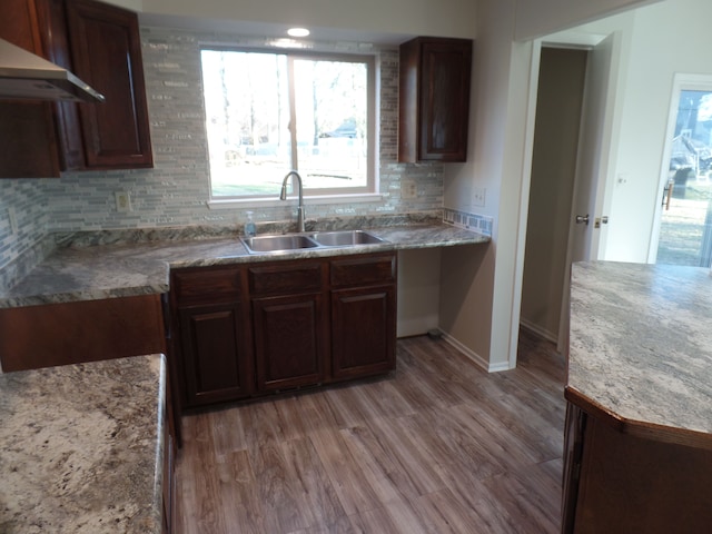 kitchen featuring light hardwood / wood-style floors, sink, extractor fan, and tasteful backsplash