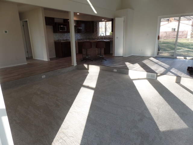 unfurnished living room with sink and a wealth of natural light