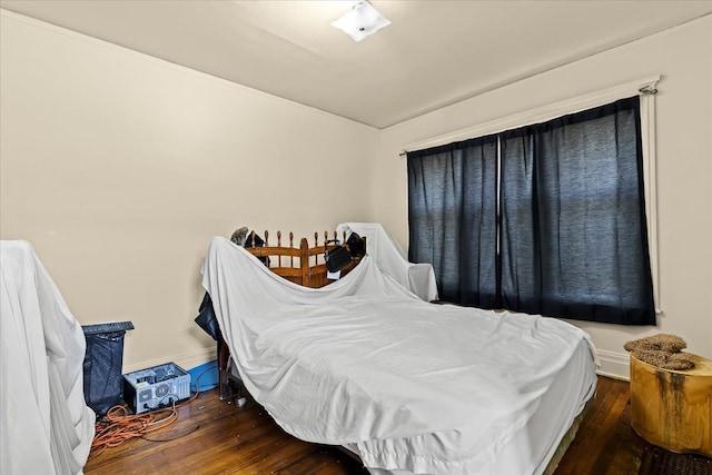 bedroom with dark hardwood / wood-style floors