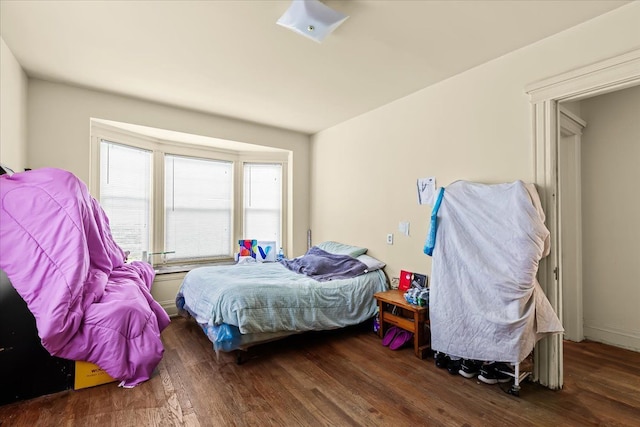 bedroom with dark wood-type flooring