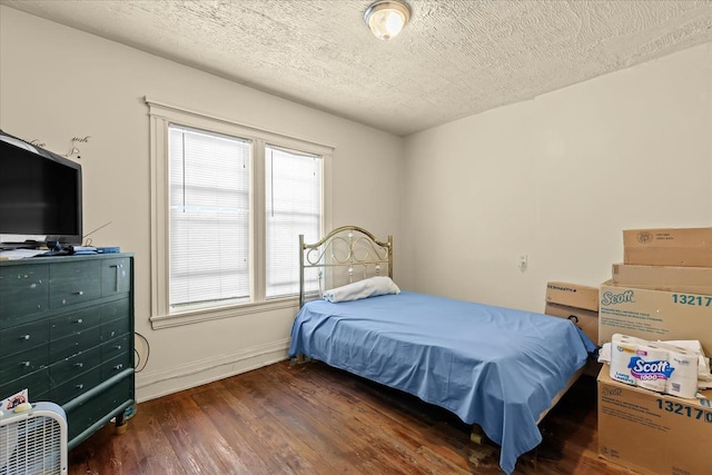 bedroom with a textured ceiling and dark wood-type flooring