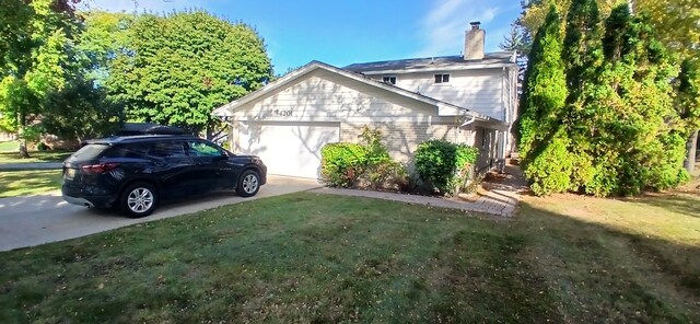 view of side of home with a lawn and a garage