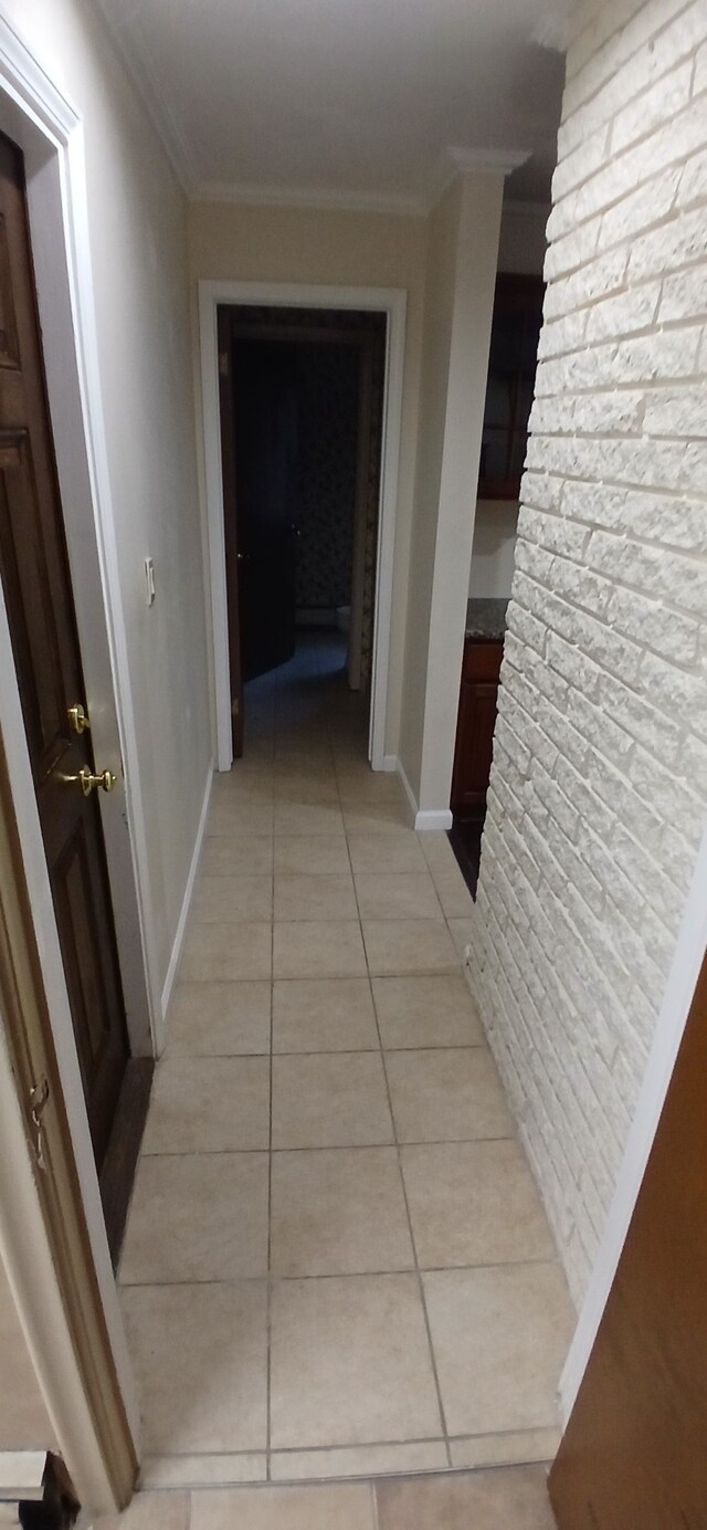 corridor featuring crown molding and light tile patterned flooring