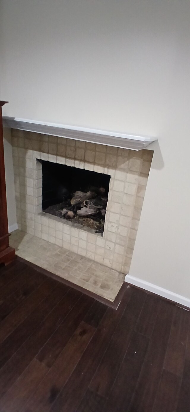 details featuring hardwood / wood-style flooring and a brick fireplace