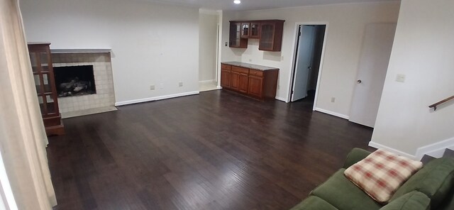 unfurnished living room with dark hardwood / wood-style flooring and ornamental molding