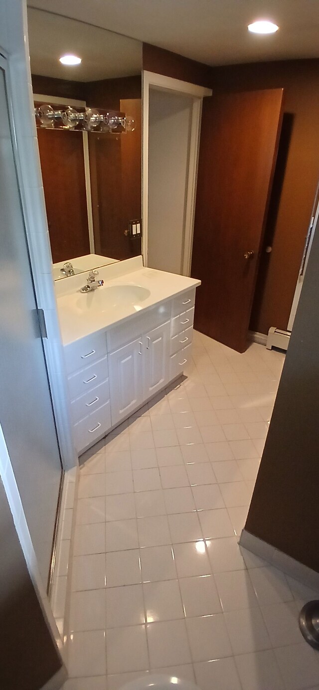 bathroom featuring baseboard heating, tile patterned flooring, and vanity