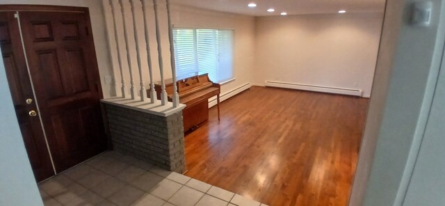 entrance foyer with hardwood / wood-style flooring and a baseboard heating unit