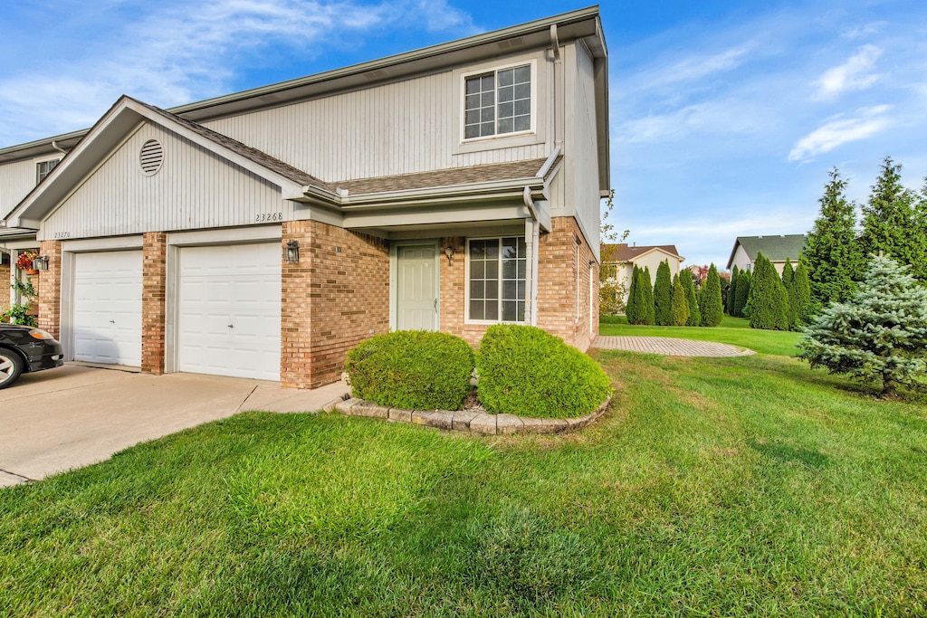 view of front property featuring a garage and a front lawn