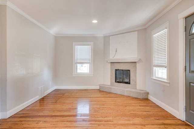 unfurnished living room featuring a fireplace, light wood-type flooring, and crown molding