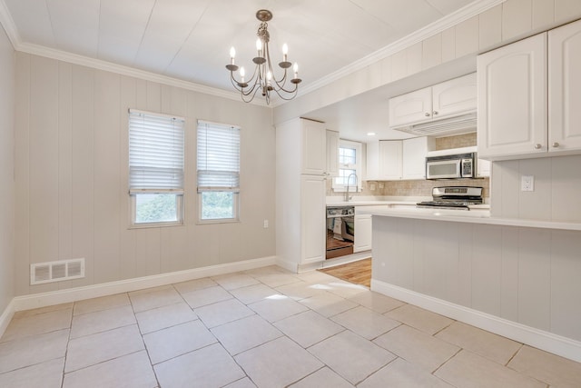 kitchen featuring tasteful backsplash, stainless steel appliances, decorative light fixtures, white cabinets, and light tile patterned flooring