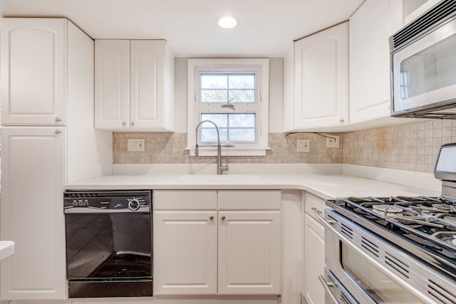 kitchen featuring decorative backsplash, appliances with stainless steel finishes, white cabinetry, and sink