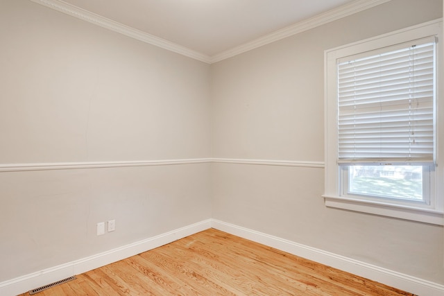 spare room featuring wood-type flooring and ornamental molding