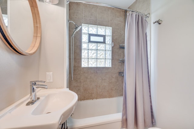 bathroom featuring shower / bath combo with shower curtain and sink