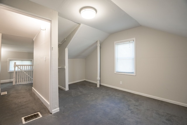 bonus room featuring dark colored carpet and lofted ceiling