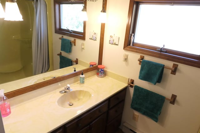 bathroom with a shower with curtain, vanity, and a healthy amount of sunlight