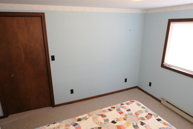 unfurnished bedroom with light carpet and a baseboard heating unit