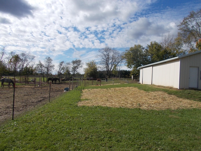 view of yard with a rural view and an outdoor structure