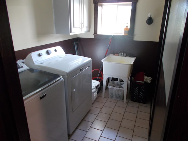 laundry area with cabinets, separate washer and dryer, and light tile patterned floors