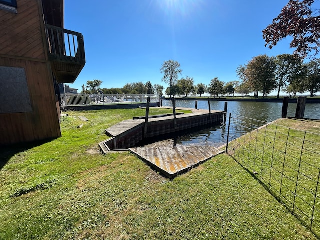 view of dock with a water view and a lawn