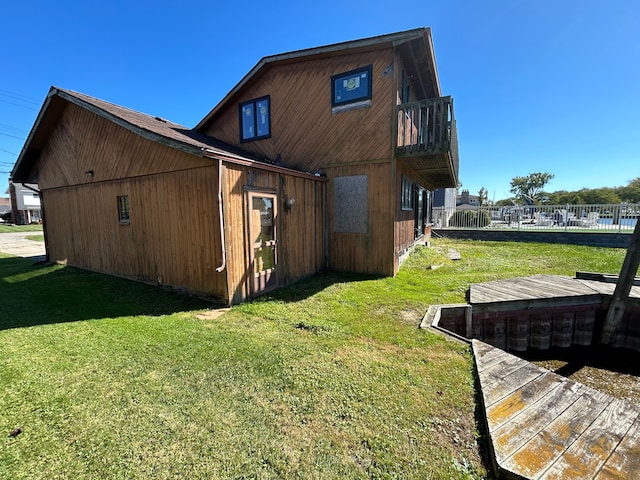 view of property exterior featuring a yard and a balcony