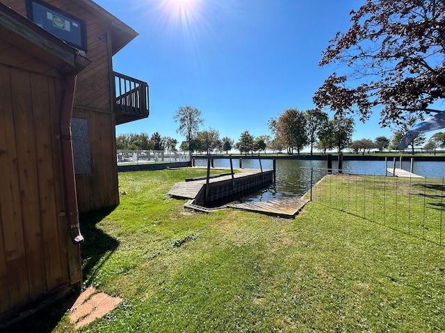 dock area with a yard and a water view