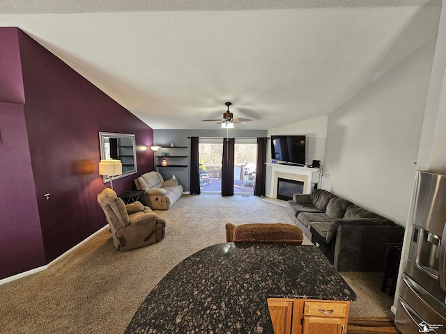 living room featuring ceiling fan, lofted ceiling, a textured ceiling, and carpet floors