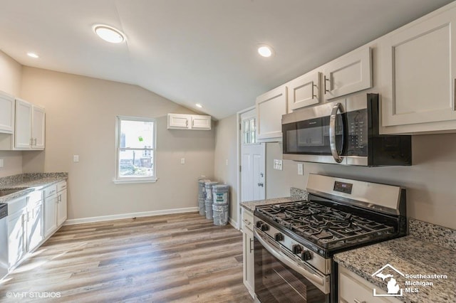 kitchen featuring white cabinets, light hardwood / wood-style floors, lofted ceiling, and appliances with stainless steel finishes