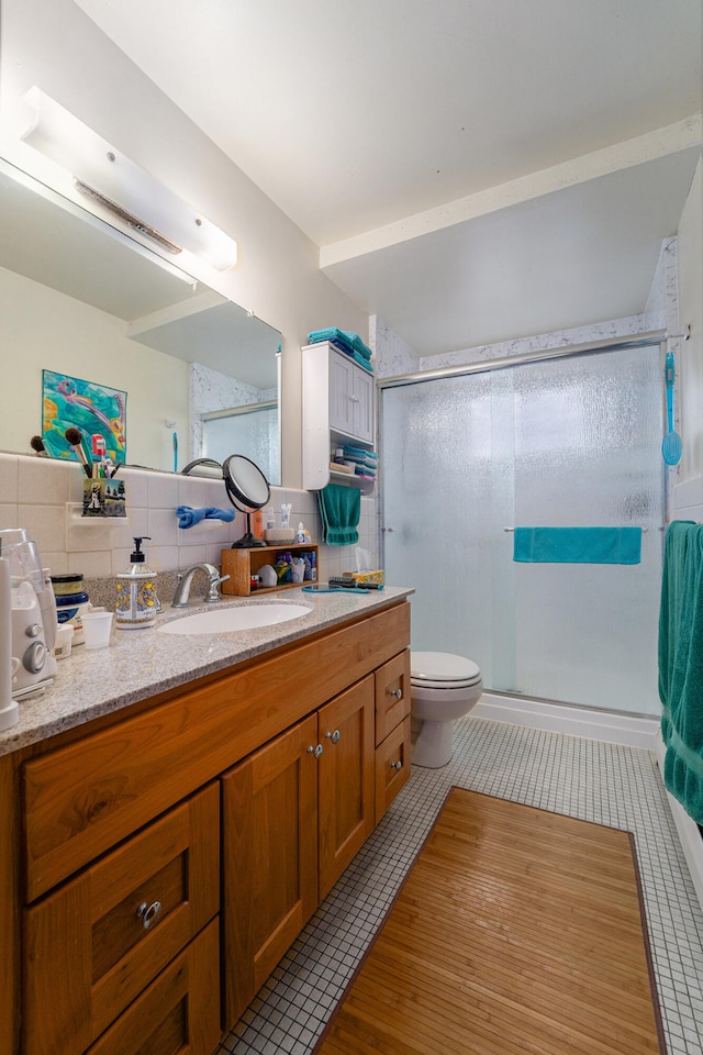 bathroom with decorative backsplash, tile patterned floors, vanity, tile walls, and a shower with shower door