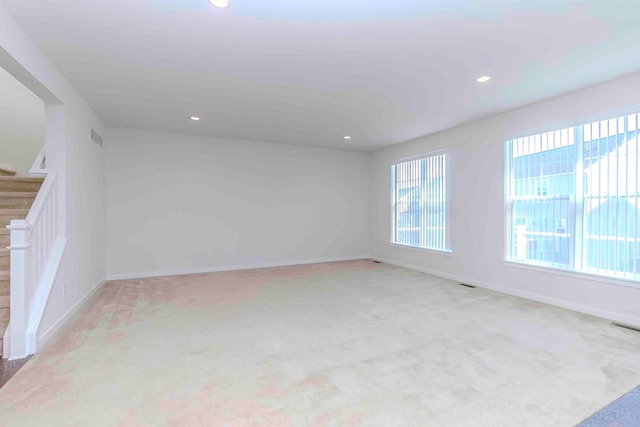 unfurnished room featuring light carpet