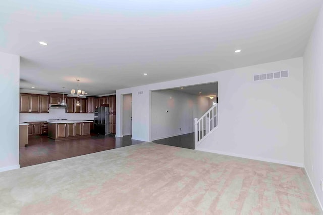 unfurnished living room with a notable chandelier and dark wood-type flooring