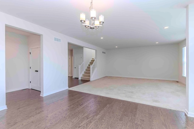 empty room with a chandelier and hardwood / wood-style flooring