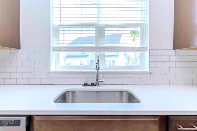 kitchen featuring dishwashing machine, tasteful backsplash, a healthy amount of sunlight, and sink