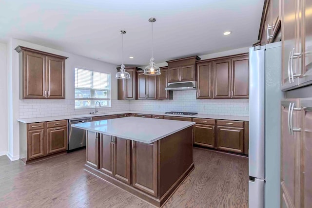 kitchen featuring dishwasher, tasteful backsplash, a kitchen island, dark hardwood / wood-style flooring, and gas cooktop