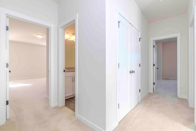 hallway featuring light colored carpet