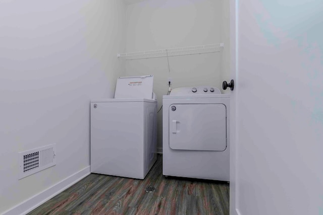 laundry area featuring washing machine and dryer and dark hardwood / wood-style floors