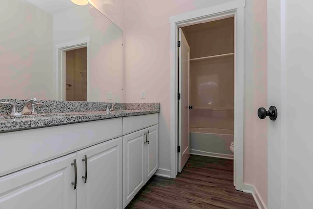 full bathroom featuring hardwood / wood-style flooring, vanity,  shower combination, and toilet